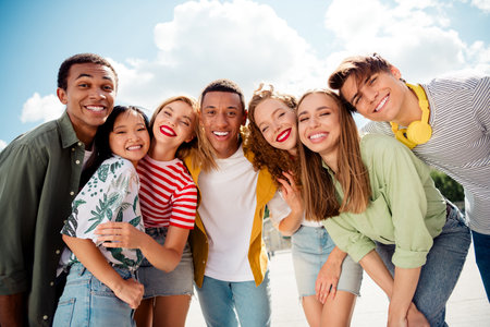 A diverse group of young people smiling together outdoors