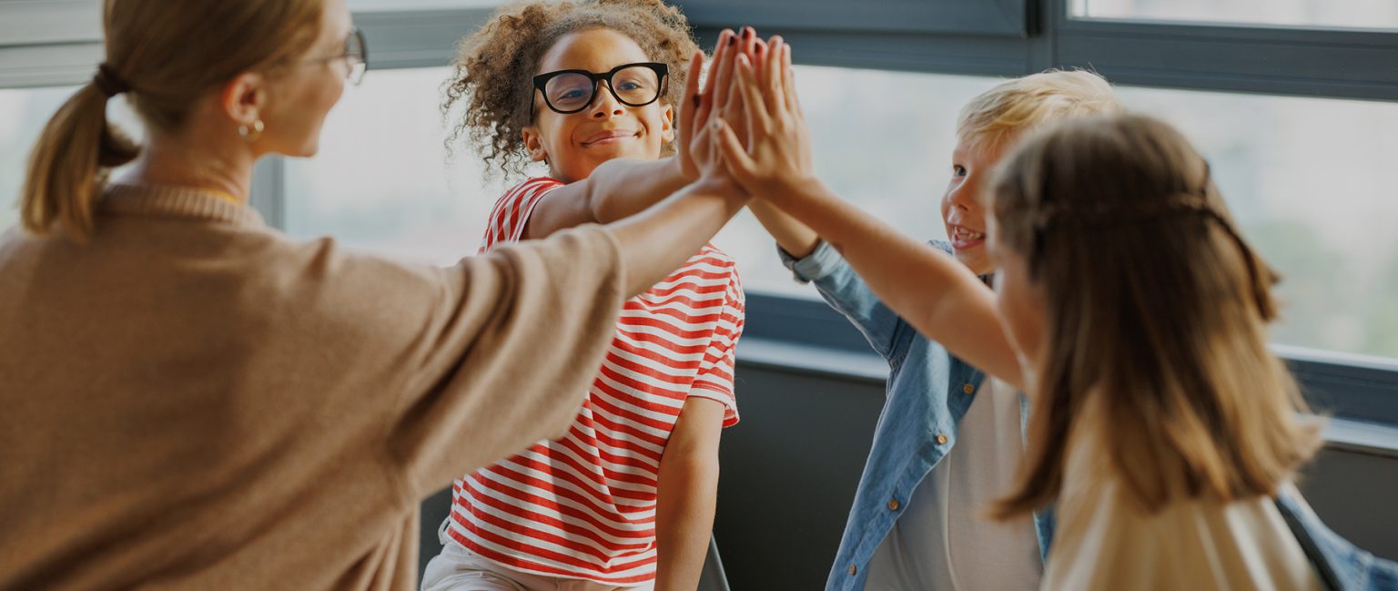 Children giving a high five during group counselling in Burlington