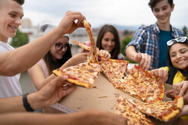 Teenagers sharing pizza during a Calm Guidance social group