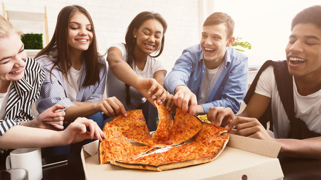 Young adults sharing pizza and enjoying relaxed social time together